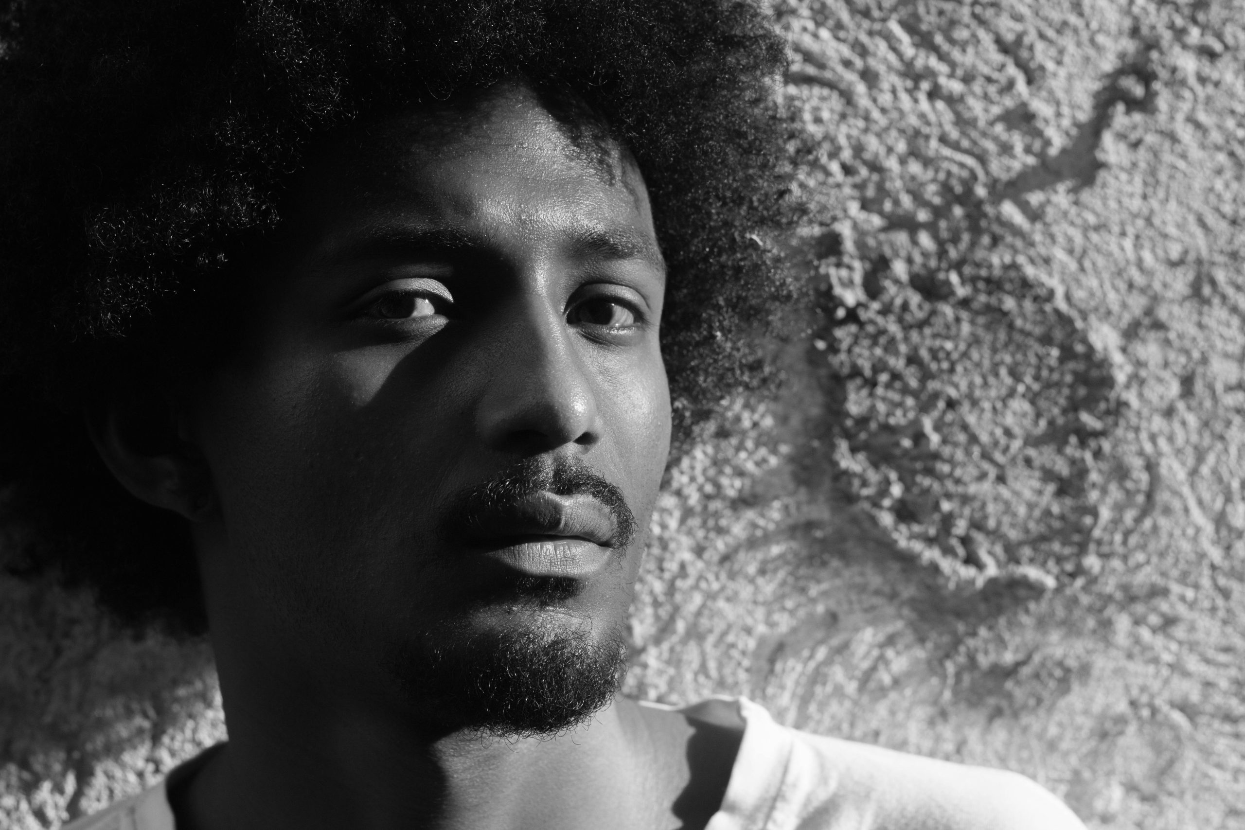Expressive monochrome portrait of a man with textured hair and beard in São Paulo.